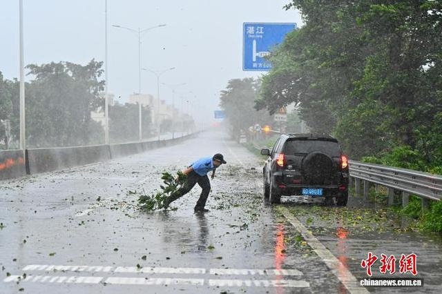 9月24日，广东阳江阳西县，一名警察清理路面上被大风吹倒的树木。中新社记者 陈骥旻 摄 