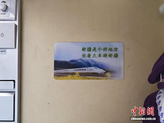 “喀什号”车厢内部，张贴着“新疆是个好地方，坐着火车游新疆”标语。中新网记者 任思雨 摄