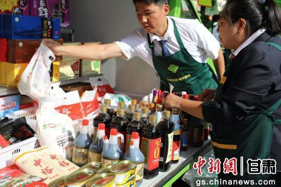 图为活动现场展示的调味品等生活必需品。