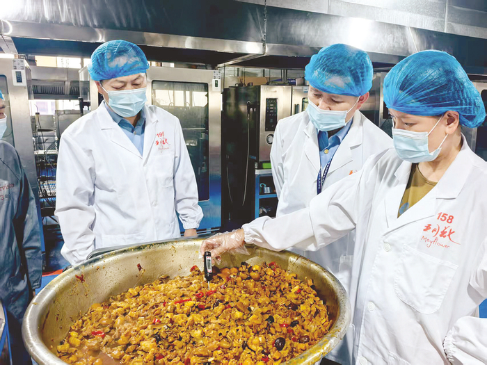     执法人员随机抽检加工完成的餐品中心温度。    （南宁市市场监管局经开分局供图）