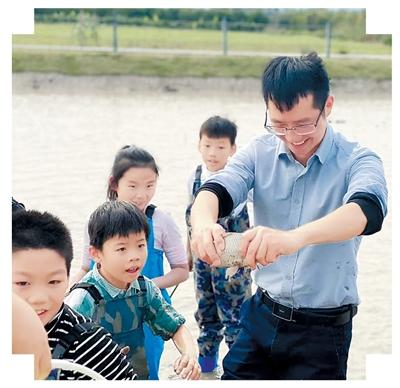 刘松带领小游客参加“浑水摸鱼”农文旅活动。王 滨摄