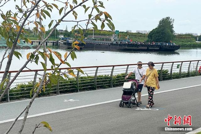 江苏昆山花桥镇，吴淞江畔，居民正在散步。高萌 摄