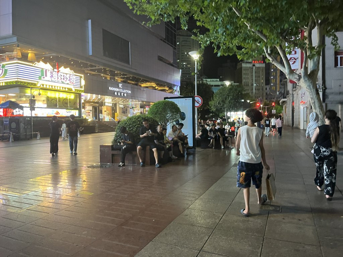 23时许，南京路步行街西面大多沿街商铺已打烊，游客在街心长椅歇脚。