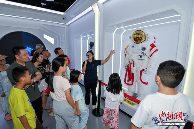 图为展出的航天服模型吸引参观者。中新社记者 骆云飞 摄 