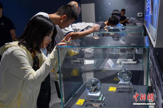 图为展出的陨石标本吸引参观者。中新社记者 骆云飞 摄 