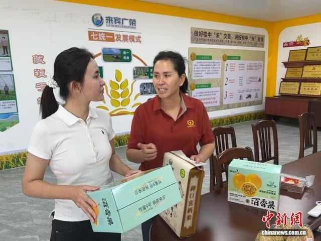 10月4日，黄少彦正在和母亲商讨产品外包装设计问题。 袁文煊 摄