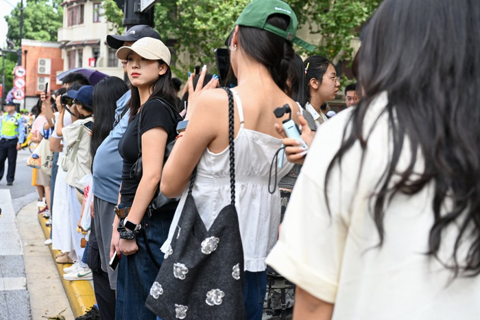 游客站在淮海中路上和武康大楼合影。澎湃新闻记者 朱伟辉 图