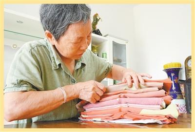 汤春梅仔细整理一面面褪色的国旗。图为姚雨婷摄