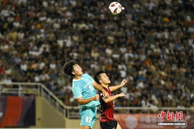 图为双方球员在比赛中拼抢。中新社记者 何蓬磊 摄