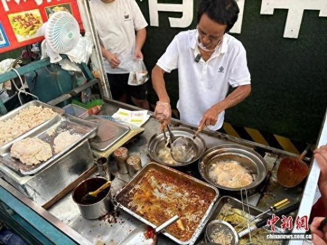 “鸡排哥”李俊永正在为食客炸制鸡排。记者 李韵涵 摄