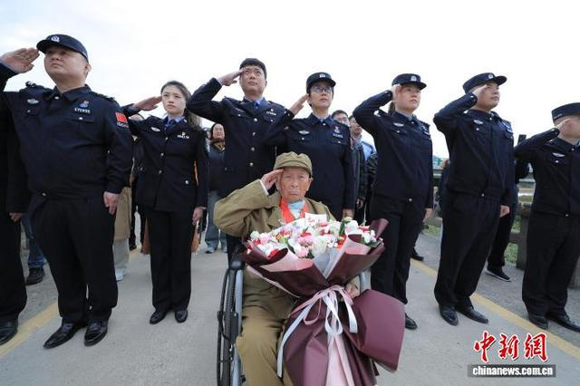 10月7日，在吉林图们口岸，金虎月老人与移民管理警察一起参加升国旗仪式。张彪 摄