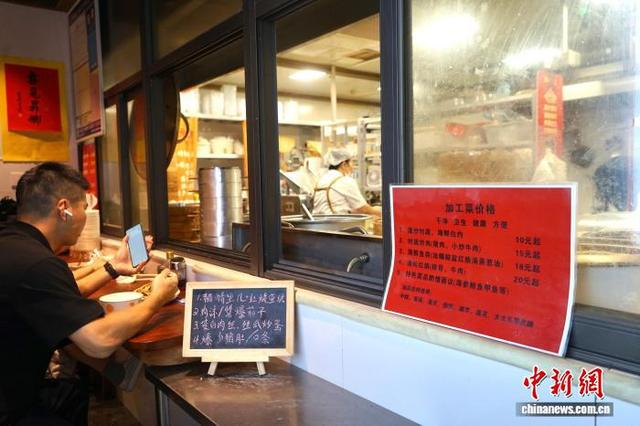 文二菜市某家商户摆出的代炒服务收费标准，以及可选用的油品佐料。蓝伊旎 摄