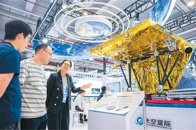 在株洲国际会展中心，工作人员（左三）在介绍一台对地观测卫星。新华社记者 陈思汗摄