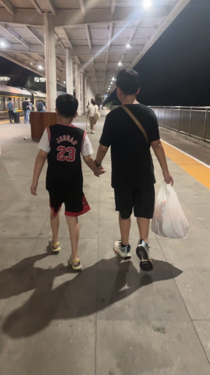 在火车站，哥哥牵着星星。