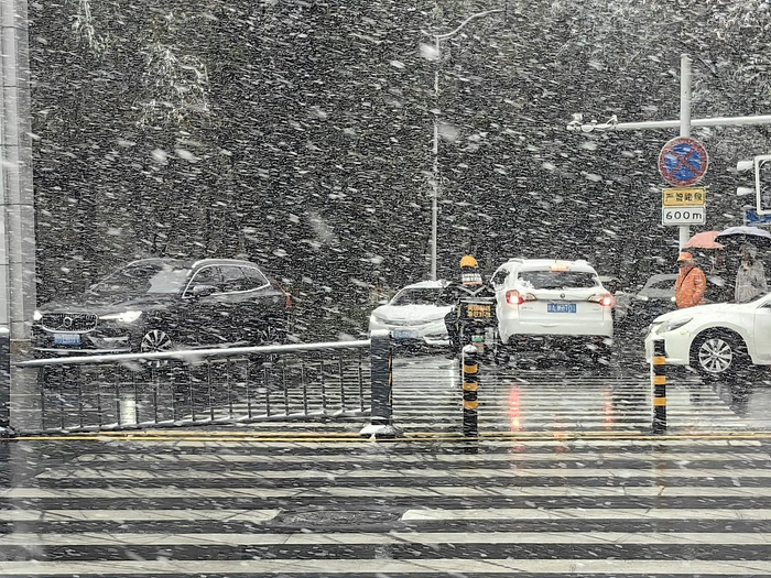  10月15日，新疆乌鲁木齐，当地迎来首场降雪，市民在早高峰时段出行。 