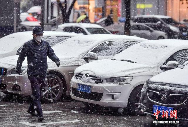 10月15日，新疆乌鲁木齐市降下皑皑白雪，街头停放的车辆被白雪覆盖。中新社记者 刘新 摄