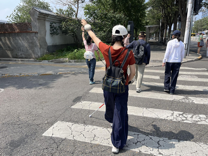 学员们学习如何过十字路口，需要挥舞手臂提醒来往车辆。新京报记者 徐鸣 摄