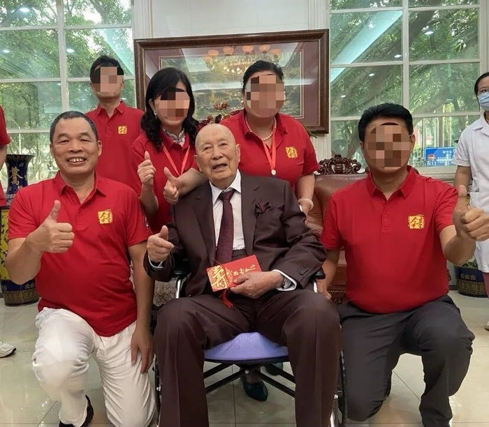 ▲杨炯（前排左一）等人身着红色衣服与钟院士合影。受访者供图