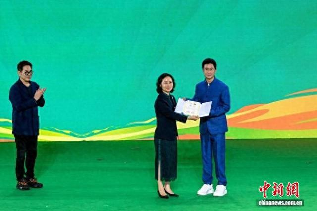 国际武术联合会秘书长张玉萍为吴京颁发“国际武术联合会和中国武术协会武术形象大使”聘书。记者 刘忠俊 摄