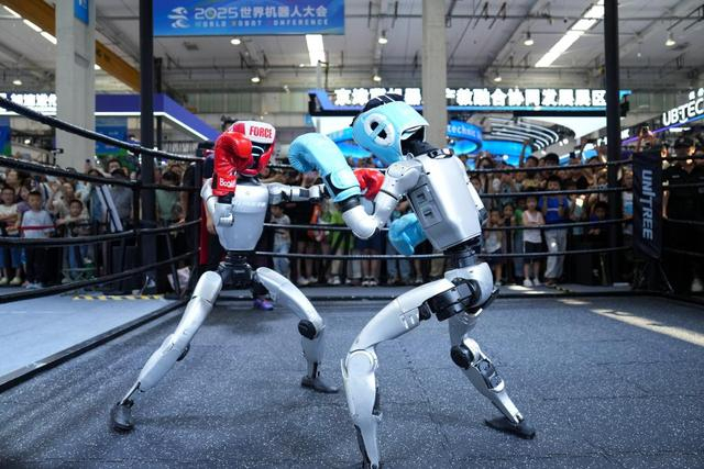 在2025世界机器人大会展馆内，观众在宇树机器人展台观看机器人拳击展示。新华社记者 鞠焕宗 摄