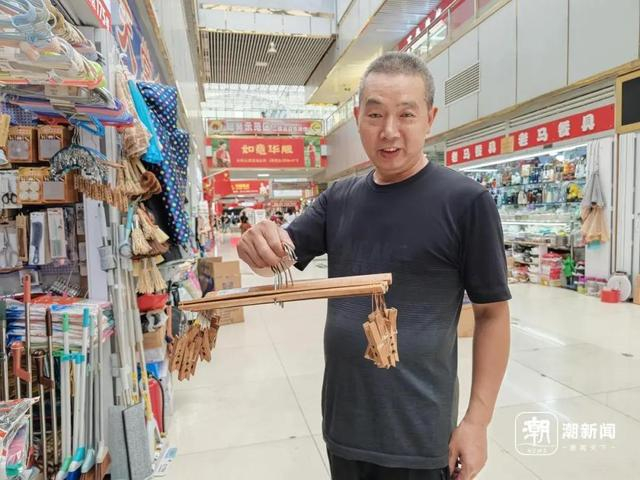 厉老板展示竹制的十字裤架。王伊灵 摄