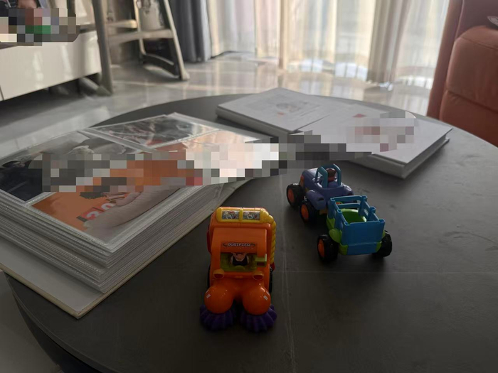 客厅茶几上摆放着宝宝的写真和玩具。 新京报记者 熊丽欣 摄