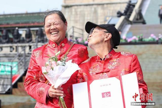 图为江西南昌滕王阁景区第八届金婚盛典活动现场，一对金婚老人展示他们的金婚证书。 刘思伟 摄