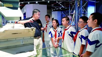 北京航空航天博物馆首席专家韩国军（左）向北航附中的同学们讲授我国航空航天事业发展历程。北京航空航天大学供图