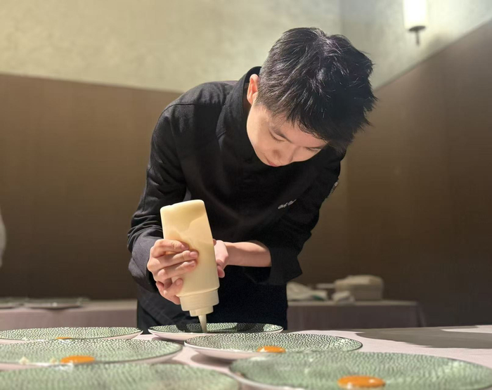  10月13日傍晚，北京，屈雨瑜（左）在后厨为晚宴做准备。新京报记者 吴淋姝 摄