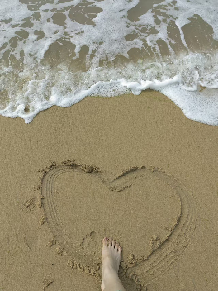 2023年7月，吴传莉在威海的海边沙滩画了一个爱心。受访者供图
