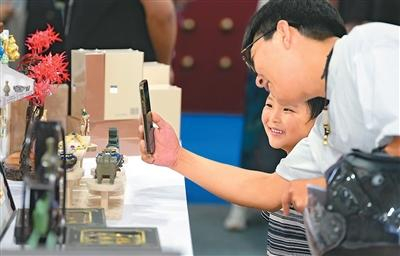 游客在良渚文创市集参观中国国家博物馆文创产品展区。新华社记者 黄宗治摄