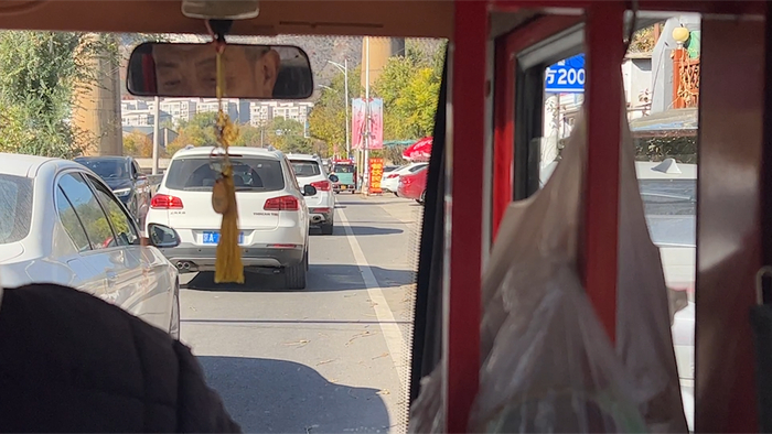 11月2日，记者搭乘的电动三轮车贴着车流前行。新京报记者 刘婧瑜 摄