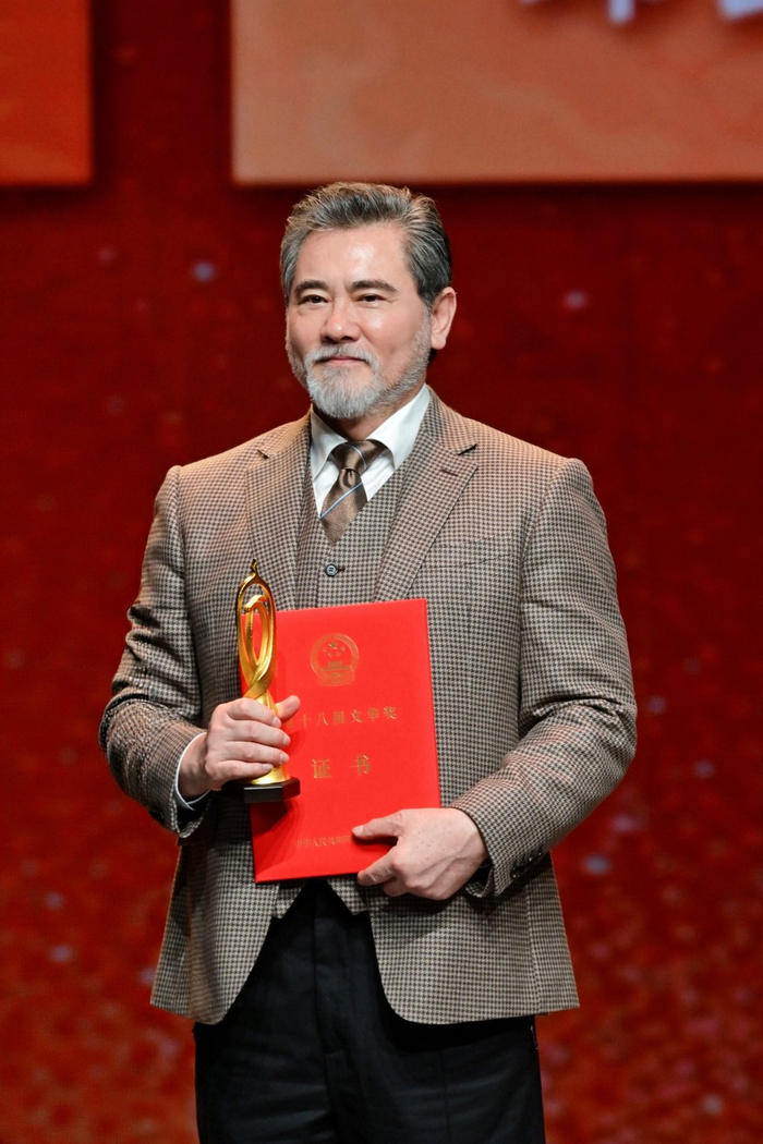 赵文瑄手捧文华奖奖杯和证书