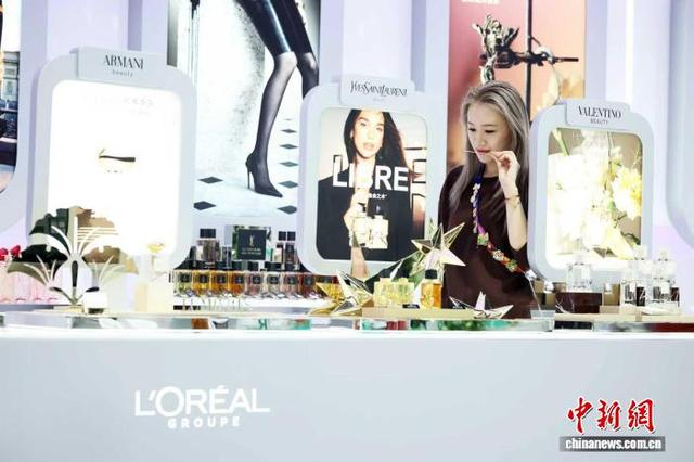 11月5日，第八届进博会上，一位年轻观众在欧莱雅展台前体验最新产品。 中新社记者 汤彦俊摄