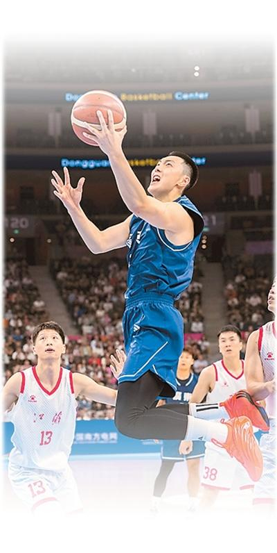 广东队球员胡明轩（上）在篮球男子成年组比赛中突破上篮。新华社记者 李博摄