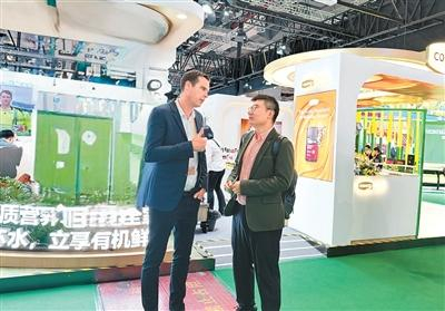 图为在第八届进博会上，王思维（右）在与新西兰客商交流。受访者供图