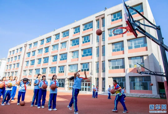 学生在体育课上练习投篮。新华网发(丁根厚 摄)