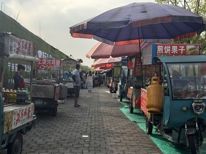 10月16日，鸡排哥出摊后，顾客被吸引过去，其他摊位变得冷清。  新京报记者 熊丽欣 摄