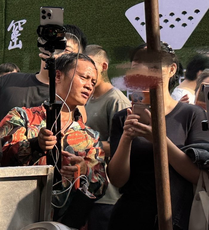 10月15日，王小江穿着花衬衫，在鸡排摊前直播。  新京报记者 熊丽欣 摄