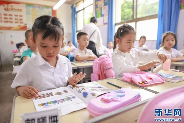 一年级新生翻开新课本阅读。新华网发(陶家淇 摄)