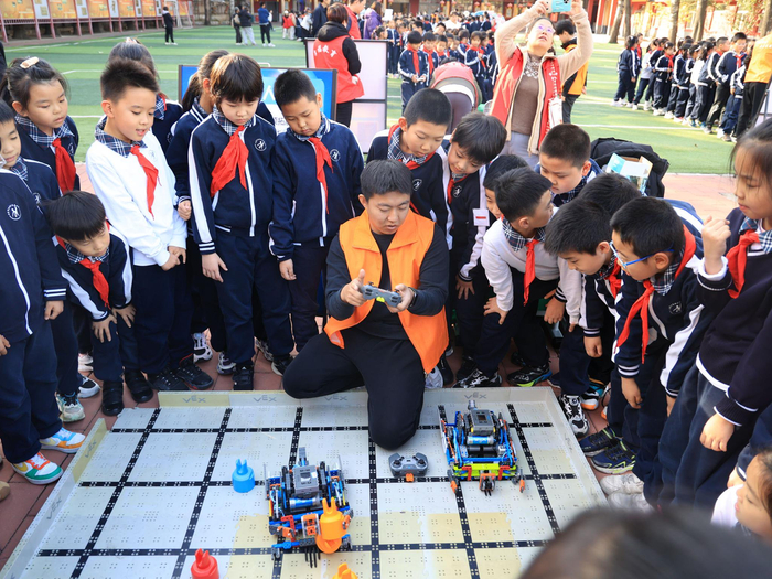 在VEXIQ机器人挑战赛体验项目中，老师在讲解手柄功能，同学们通过编程可以控制机器人的动作，完成制定任务。 学校供图