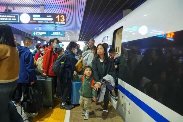 11月12日，成都火车站，家长带着孩子出行。成都商报 图