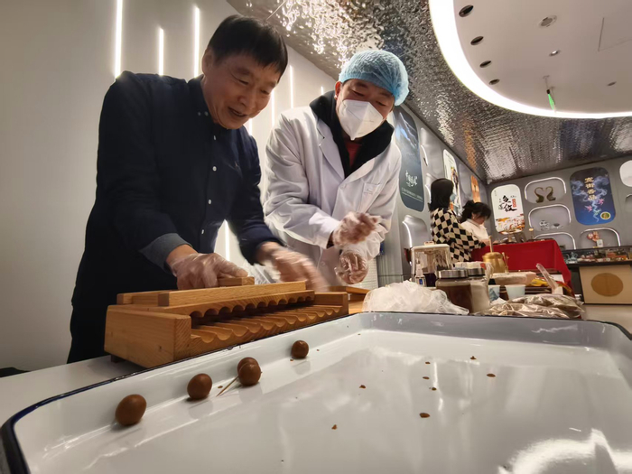 药工现场演绎“手工塑制蜜丸”古法炮制技艺。新京报记者 吴婷婷 摄