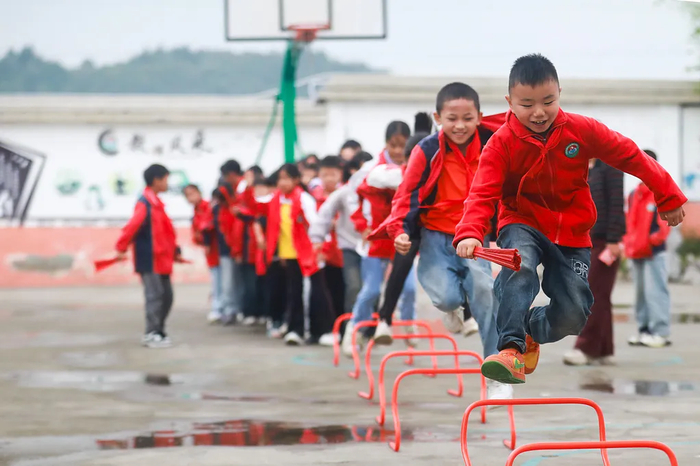 △贵州黔西，绿化白族彝族乡培育小学学生在课间跳小栏架。