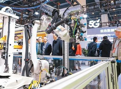 日前，参观者在2025中国5G+工业互联网大会展厅观看展出的一款柔性制造岛式工作站。新华社记者 肖艺九摄