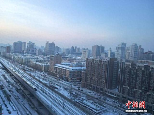 11月26日晚，哈尔滨市迎来降雪天气，铁路和公路两旁都覆盖着一层白雪。 姜辉 摄