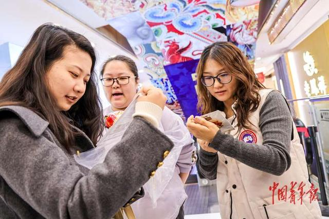 11月28日，北京王府井工美大厦，几名年轻人在选购“马墩墩”。中青报·中青网记者 陈思阳/摄