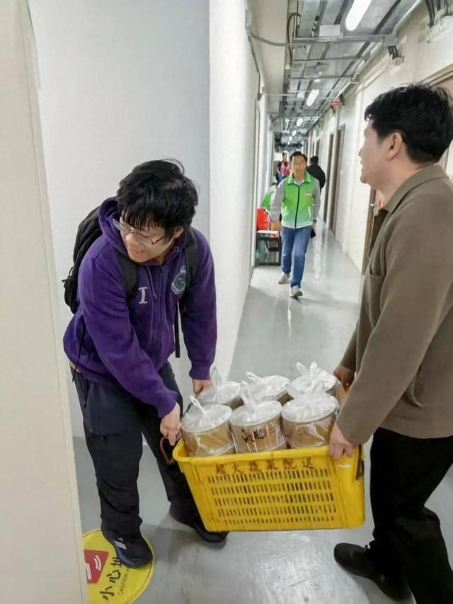 自治区政协委员、香港广西社团总会副会长陈博智（右）在香港协助派餐给受灾居民。自治区政协办公厅供图