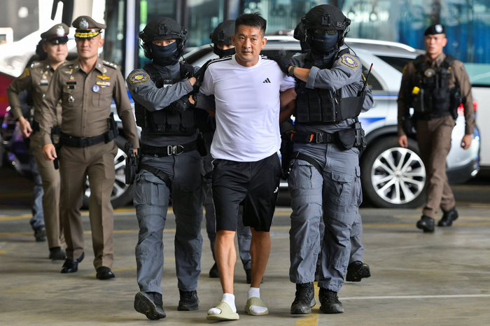 当地时间2025年11月12日，泰国警方将佘智江押送至曼谷素万那普机场，并押送上飞机，引渡回中国。图/IC photo