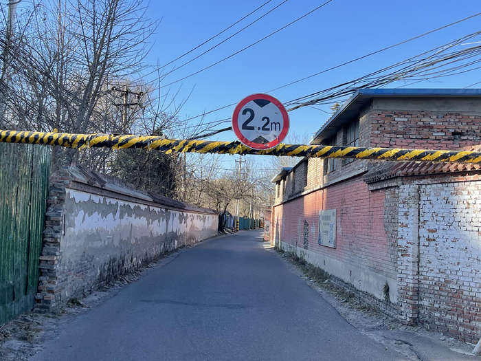 榆树庄村村委会南侧小路仅宽约3米，路口处贴着2.2米的限高提示牌。新京报记者 吴婷婷 摄